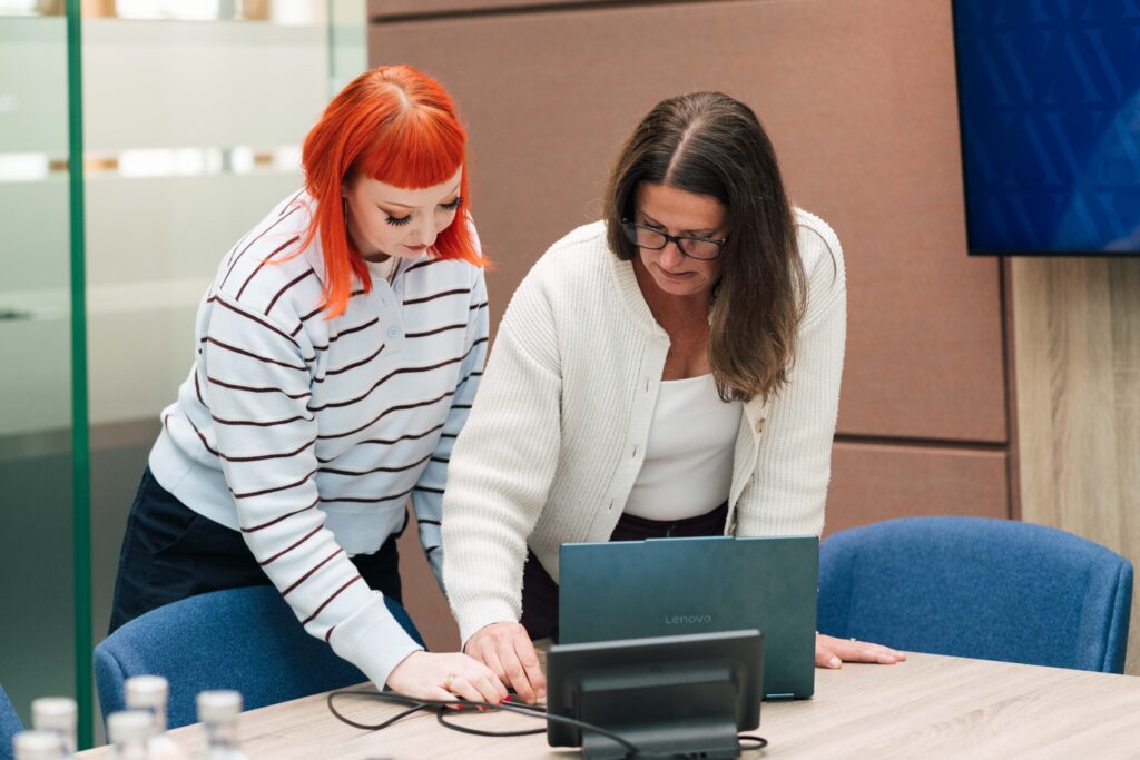 Digital Modus management members standing and looking at the laptop